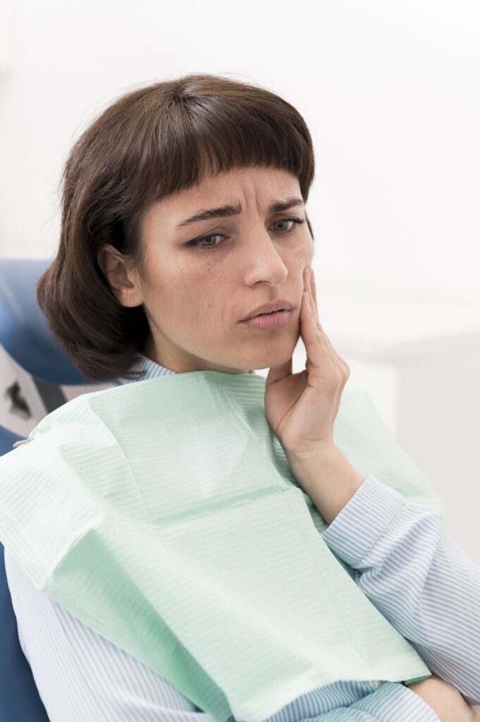 Foto di una paziente in visita da un dentista che soffre per un problema dentale